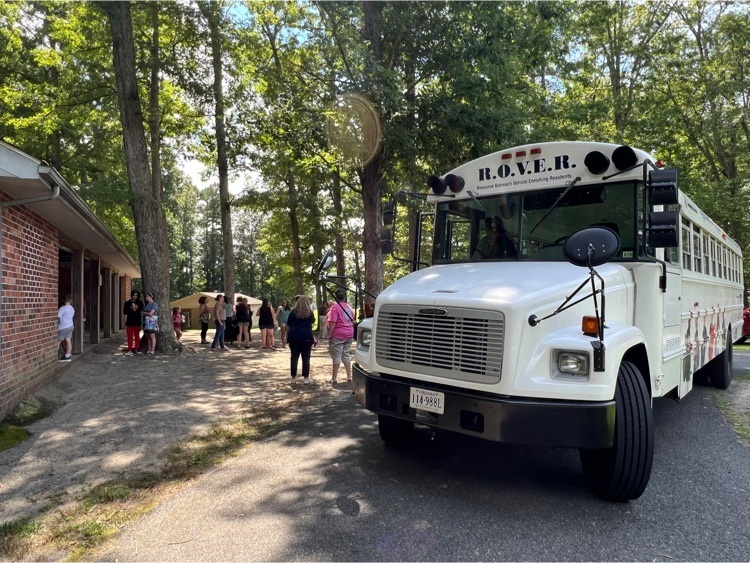 ROVER white school bus delivering books at a park